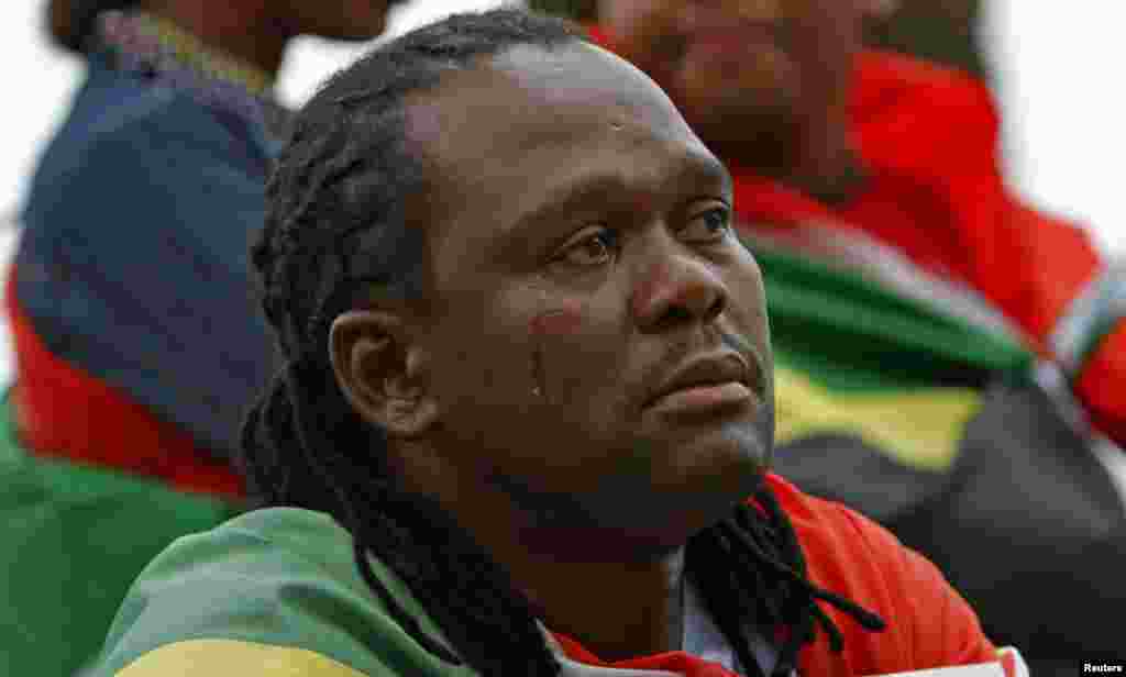 Seorang laki-laki menangis saat menyaksikan upacara pemakaman mantan presiden Afrika Selatan Nelson Mandela di televisi layar lebar di Cape Town, Afrika Selatan, 15 Desember 2013.