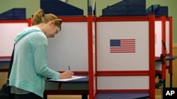 FILE - A woman casts marks her ballot during primary voting in Durham, N.C., May 8, 2018. 
