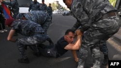 Armenian police officers detain a protester during a rally against land transfer to Azerbaijan, in Yerevan on April 27, 2024.