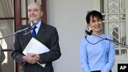 French Foreign Minister Alain Juppe and Burmese pro-democracy leader Aung San Suu Kyi attend a press conference after their meeting at her lake side residence in Rangoon, Burma, January 15, 2012.