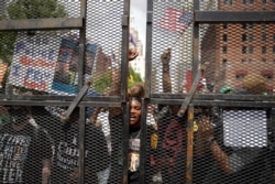 Protesters stand outside the BOK Center where President Donald Trump will hold a campaign rally in Tulsa, Okla., June 20, 2020.
