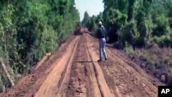 Workers push to quickly complete a makeshift levee by packing dirt on top of an old railroad bed in the Green Meadow neighborhood of South Vicksburg, Mississippi, May 2011