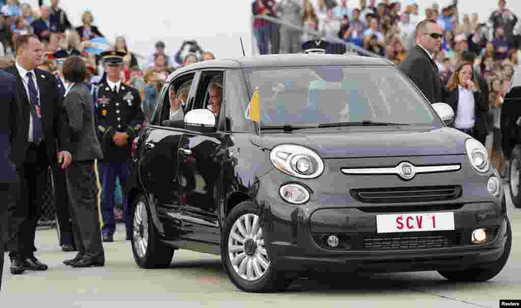 Paus Fransiskus melambaikan tangan dari dalam mobil Fiat 500 yang membawanya keluar dari Pangkalan Militer Gabungan Andrews di luar Washington (22/9). (Reuters/Jonathan Ernst)