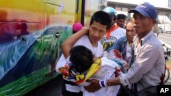 Demonstran anti-pemerintah Thailand membawa demonstran yang terluka dari bis ke ambulance pasca serangan kelompok bersenjata di Bangkok (1/4). 