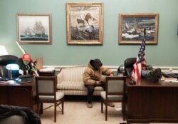 Supporters of U.S. President Donald Trump sit inside the office of U.S. Speaker of the House Nancy Pelosi as they protest inside the U.S. Capitol in Washington, Jan. 6, 2021.