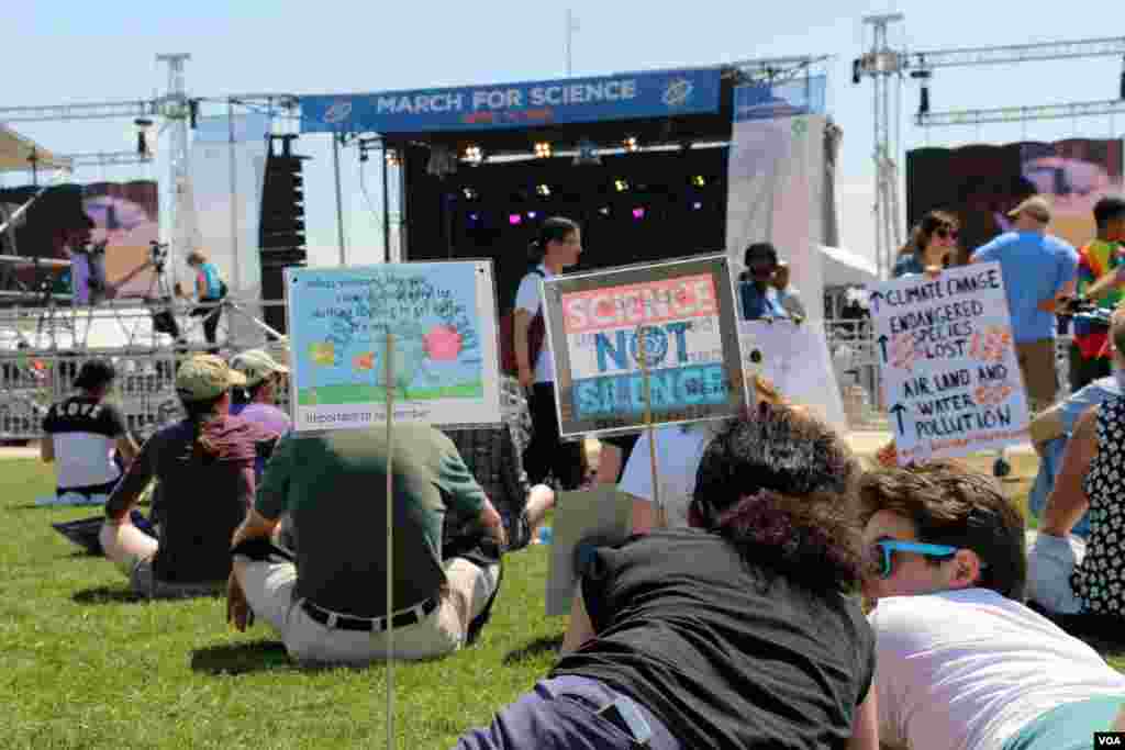 គូ​ស្នេហ៍​មួយ​គូ​ចូលរួម​គាំ​ទ្រ​ចលនា​ដើរ​ជា​ក្បួន​ដើម្បី​លើក​កម្ពស់​វិទ្យាសាស្ត្រ ហើយ​យក​សញ្ញា​និង​បដា​គាំទ្រ​ដល់​វិទ្យាសាស្ត្រ​មក​ជាមួយ។ (ចាប ចិត្រា/VOA)