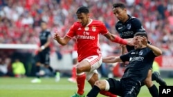 Eduardo Salvio, à gauche, se bat pour le ballon avec Guimarães Joao Aurelio, lors d'un match entre Benfica et Vitoria de Guimaraes, Portugal, le 13 mai 2017