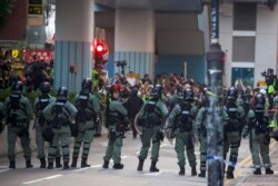Riot police stand guard as lawyer and newly elected district councillor arrive at the Polytechnic University to meet the left-over protesters in Hong Kong, Nov. 25, 2019.