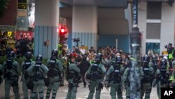 Riot police stand guard as lawyer and newly elected district councillor arrive at the Polytechnic University to meet the left-over protesters in Hong Kong, Nov. 25, 2019. 