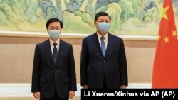 Presiden China Xi Jinping, kanan, dan Kepala Eksekutif Hong Kong John Lee di Beijing, Senin, 30 Mei 2022. (Foto: Xinhua via AP)