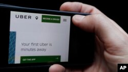 FILE - The Uber website is displayed on a phone in London, Sept. 22, 2017. 