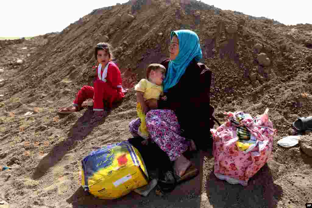 An Iraqi woman who fled her village holds her daughter near a Kurdish checkpoint, in the Khazer area between Mosul and Irbil, northern Iraq, June 26, 2014.