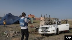 Wafanyakazi wa Umoja wa Mataifa wakikagua mabaki ya gari iliyokuwa ikitumiwa na Kikundi cha msaada cha World Central Kitchen chenye makao makuu Marekani, ambalo lilipigwa na kombora la Israeli huko Deir al-Balah, katikati ya Ukanda wa Gaza April 2, 2024.