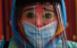 Clown Tapetito, wearing protective gear amid the new coronavirus, poses for a photo before disinfecting a home free of charge, in El Alto, Bolivia, Sept. 11, 2020.