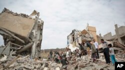 Warga memeriksa rumah-rumah yang hancur akibat serangan udara tentara koalisi pimpinan Saudi di Sanaa, Yaman, Jumat, 25 Agustus 2017.