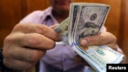 An employee counts money in a foreign exchange office in central Cairo, Egypt, November 3, 2016. The wide gap between Egypt's official and unofficial dollar rates has led people to insist on receiving their money in foreign currency from the bank and the