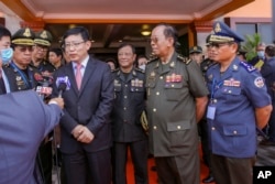 ឯកអគ្គរដ្ឋទូត​ចិន​ប្រចាំ​នៅ​កម្ពុជា លោក Wang Wentian (ឆ្វេង) និយាយ​ទៅ​កាន់​អ្នក​កាសែត ខណៈ​ដែល​រដ្ឋមន្ត្រី​ក្រសួង​ការពារ​ជាតិ លោក ទៀ បាញ់ (ស្ដាំ) ឈរ​ស្ដាប់ ក្នុង​អំឡុងពេល​នៃ​ពិធី​បញ្ចុះបឋមសិលា និងបើកការដា្ឋនសាងសង់រោងជាងជួសជុលនាវា និងផែសំចត នៅ​មូលដ្ឋាន​កងទ័ព​ជើងទឹក​រាម ក្នុង​ខេត្ត​ព្រះសីហនុ ថ្ងៃទី ៨ ខែមិថុនា ឆ្នាំ២០២២។ (Cambodia's Fresh News via AP)