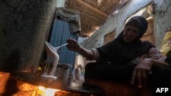 Seorang perempuan menyiapkan roti di rumahnya di Desa Zerzara, Mesir, pada 26 Februari 2022. Banyak pihak yang khawatir invasi Rusia ke Ukraina dapat menyebabkan krisis pangan pada negara-negara seperti Mesir, Lebanon, dan lainnya. (Foto: AFP/Khaled Desouki)