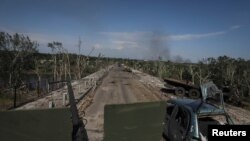 FILE - Members of a foreign volunteers unit which fights in the Ukrainian army drive on a military vehicle, as Russia's attack on Ukraine continues, in Sievierodonetsk, Luhansk region Ukraine, June 2, 2022.
