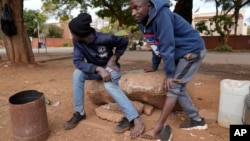 Street vendors take off their shoes to show their toes on the streets of Harare, Zimbabwe, June, 9, 2022. 