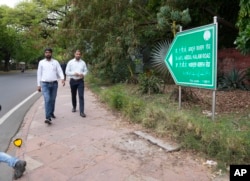 People walk on a road earlier named Aurangzeb Road, after the Mughal emperor, now renamed to Dr. A.P.J Abdul Kalam, India's former president, in New Delhi, Thursday, June 2, 2022.