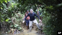 Jurnalis Inggris Dom Phillips, kanan, dan seorang pria Suku Yanomami berjalan di desa Maloca Papiu, negara bagian Roraima, Brazil, November 2019. (Foto: AP)