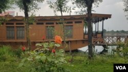 Flowers adorn a lawn area adjacent to a houseboat anchored on the banks of Kashmir's Nigeen Lake. (Bilal Hussain/VOA)