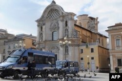FILE - Carabinieris guard in front of the damaged Santa Maria del Suffragio' s church in the historic center of the Abruzzo capital L'Aquila, Apr. 9, 2009.