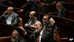 Lawmakers celebrate the defeat of a law on the legal status of Jewish settlers in the occupied West Bank, during a session of the Knesset, Israel's parliament, in Jerusalem, June 6, 2022.