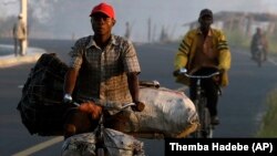 A man on a bicycle carries charcoal to sell at Mafambisse, about 60km outside of Beira, Mozambique, Tuesday, March 26, 2019.