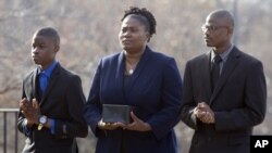 Isatu Salia carries the cremains of her husband, Ebola victim Dr. Martin Salia, while their sons Maada, 20, right, and Hinwaii, 12, walk with her to enter St. Mary's Church in Landover Hills, Md., for a funeral Mass, Nov. 29, 2014.