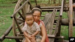 A mother and child of the Phnong tribal group rest after scouring for food in Kampong Pneu, a remote, poor region of northeastern Cambodia.