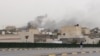 In this image made from video provided by the Libyan national army via AP Television, smoke rises over the parliament area after troops of Gen. Khalifa Hifter targeted Islamist lawmakers and officials at the parliament in Tripoli, Libya, Sunday, May 18, 2