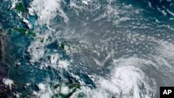 This satellite image provided by the National Oceanic and Atmospheric Administration shows Hurricane Elsa moving through the Caribbean, over Barbados, July 2, 2021, at 12:00 Z (8am a.m. ET).