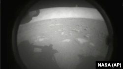 This photo made available by NASA shows the first image sent by the Perseverance rover showing the surface of Mars, just after landing in the Jezero crater, on Thursday, Feb. 18, 2021. 