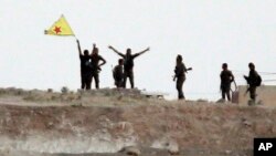 Para pejuang Kurdi merayakan kemenangan setelah merebut kota Tal Abyad, Suriah dari ISIS (15/6). Pasukan Kurdi kembali merebut satu kota lagi, Ain Issa di Suriah utara 23/6. 