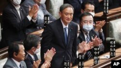 Yoshihide Suga berdiri di depan anggota Parlemen Jepang di Tokyo, 16 September 2020 setelah terpilih sebagai PM baru Jepang. (AP Photo/Koji Sasahara)