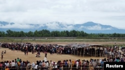 ជន​ភៀស​ខ្លួន​ Rohingya ជន​តម្រង់ជួរ​ដើម្បី​យក​អាហារ​នៅ​ក្នុង​ជម្រង់​មួយ​ក្បែរ​ Teknaf ប្រទេស​បង់ក្លាដែសកាលពី​ថ្ងៃទិ​១២ តុលា ២០១៧។