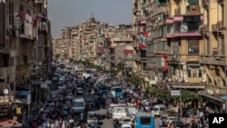 FILE - People crowd a street a few hours ahead of curfew in Cairo, Egypt, April 14, 2020. security agencies have tried to stifle criticism about the handling of the coronavirus pandemic by the government of President Abdel Fattah el-Sissi.