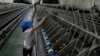 FILE- A woman works at a yarn-weaving plant of the Ha Nam textile company in Phu Ly city, about 60 km (37 miles) south of Hanoi, July 4, 2013. 