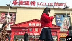 Warga melintasi Lotte Mart dimana tindakan pengamanan tampak di Beijing, China, 17 Maret 2017 (foto: AP Photo/Ng Han Guan)