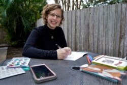 Kara McKlemurry poses for a photo while writing Thanksgiving notes to family and friends at her home, November 19, 2020, in Clearwater, Florida. On any normal Thanksgiving Day, McKlemurry and her husband would gather with family.