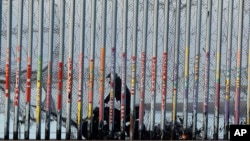 A U.S. Border Patrol agent rides a vehicle on the beach in San Diego, Jan. 9, 2019, seen through the border wall from Tijuana, Mexico. 