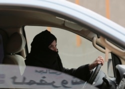 FILE - A woman drives a car on a highway in Riyadh, Saudi Arabia, March 29, 2014.