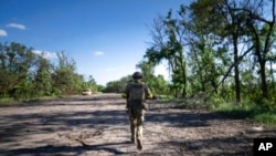 A Ukrainian serviceman changes his position at the front line near Kharkiv, Ukraine, on July 2, 2022.