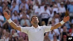 Serbia's Novak Djokovic celebrates after beating Australia's Nick Kyrgios to win the final of the men's singles on day fourteen of the Wimbledon tennis championships in London, July 10, 2022. 