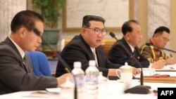 This picture released June 24, 2022, by the Korean Central News Agency shows North Korean leader Kim Jong Un, center, at a meeting of the Eighth Central Military Commission of the Workers' Party of Korea, at the party's central committee headquarters in Pyongyang.