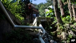 Pipes from the sewage treatment biosystem snake through the Enchanted Valley sustainable community on the outskirts of Tijuca National Forest in Rio de Janeiro, Brazil, June 6, 2022.