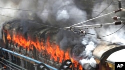 Flames rise from a train set on fire by protesters at Secundrabad railroad station in Hyderabad, India, June 17, 2022. 