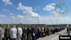 Sejumlah tahanan berbaris di jalanan dalam proses pertukaran tawanan perang antara pasukan Rusia dan Ukraina di Zaporizhzhia, Ukraina, dalam foto yang dirilis pada 29 Juni 2022. (Foto: Courtesy of Ukraine's Military Intelligence/Handout via Reuters)